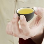 hand holding cup of green tea