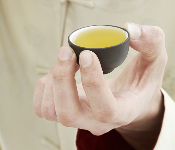 hand holding cup of green tea