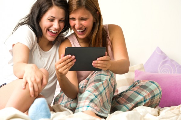 Best friends laughing browsing social network