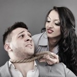 Man being tied by his neck with a rope by a woman