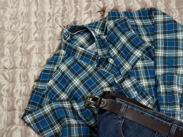 Men's casual checkered shirt and jeans on the bed