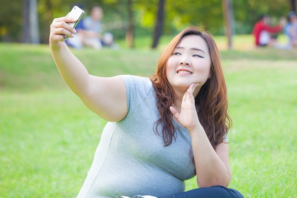 Pretty fat female takes travel selfie