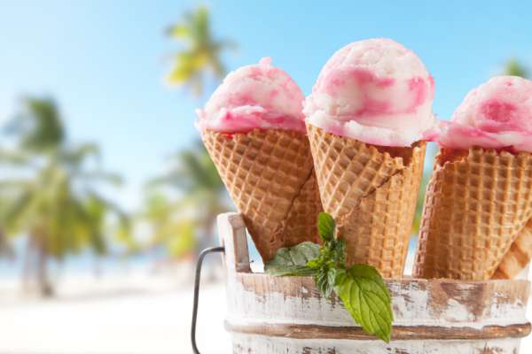 Fruit ice cream with blur beach as background. Served on wooden planks