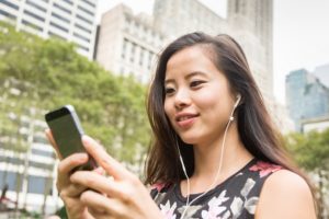 Beautiful Asian Young Woman with Mobile Phone and Earphones