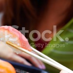 stock-photo-20007114-woman-holding-sushi-with-chopsticks