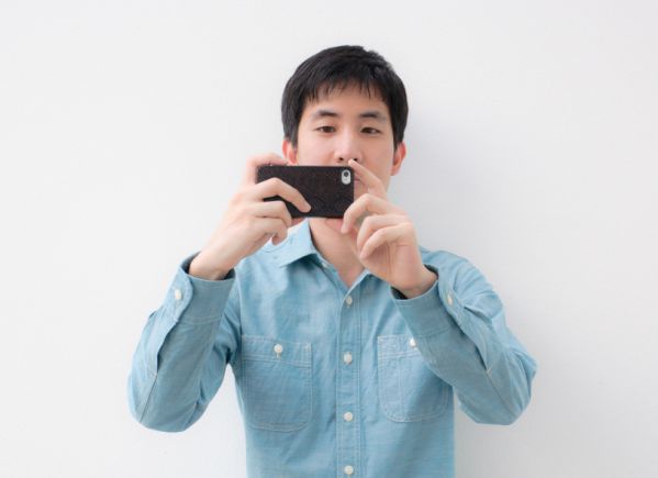 sirabee_asian man taking photos with smartphone