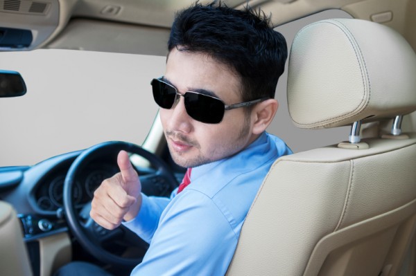 Successful person showing thumb up in car