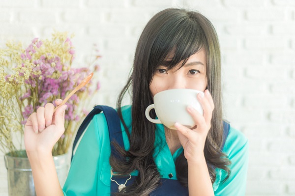 Beautiful young asian woman with a cup of tea at a cafe