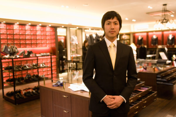 Male salesclerk at men's clothing counter