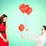 Man approaching woman giving her red heart shape balloons