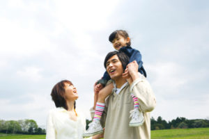 Mother escorting to father with their daughter on his shoulders