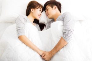 happy young lovely couple lying in a bed