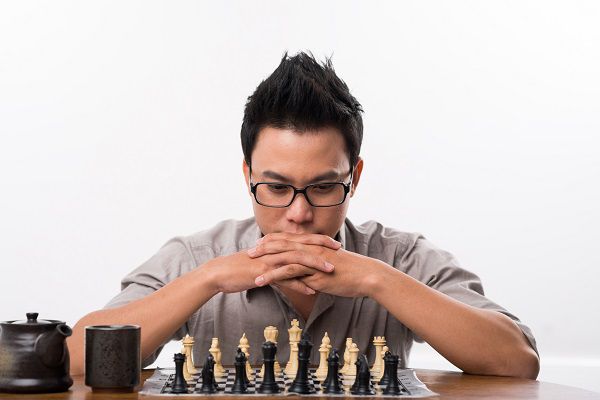Portrait of Vietnamese chess player thinking about next move