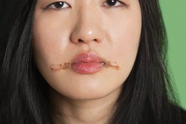 Portrait of a young woman with chocolate stains around her lips