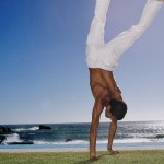 Young man doing a handstand on the grass