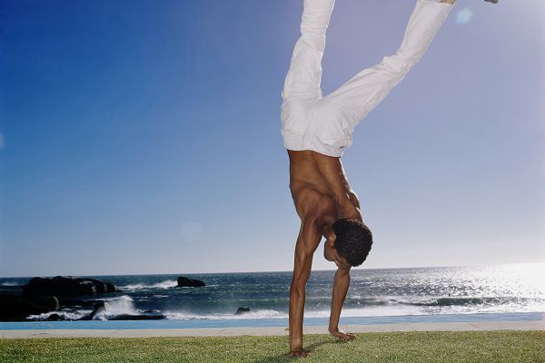 Young man doing a handstand on the grass