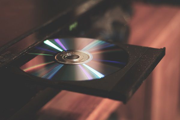 Closeup of a DVD disc in a disc player tray shiny side up