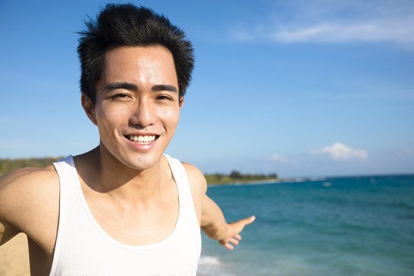 relaxing and smiling young man on the beach