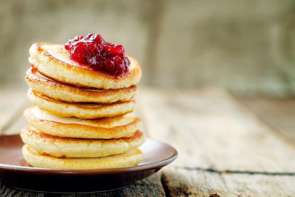 pancakes with berry jam on a dark wood background. tinting. selective focus