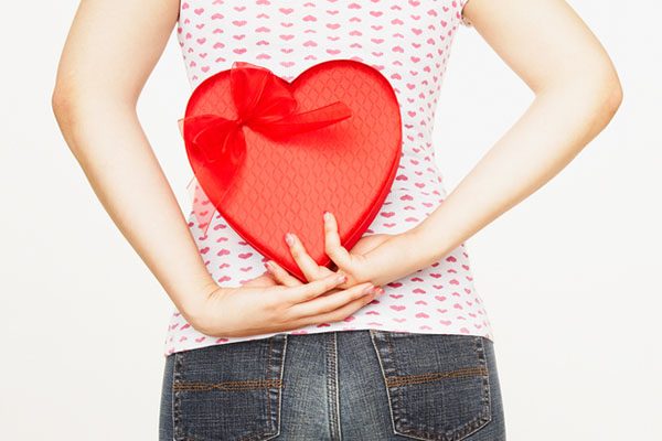 Pacific Islander woman holding heart-shaped box