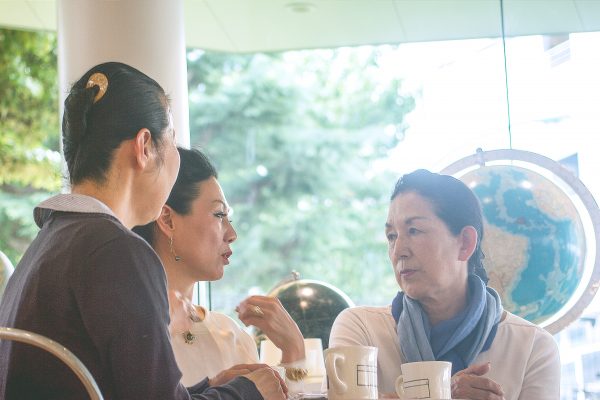 Three women talking siriously at a cafe shop