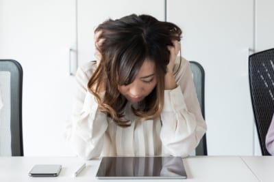 タブレットを見て困る女性