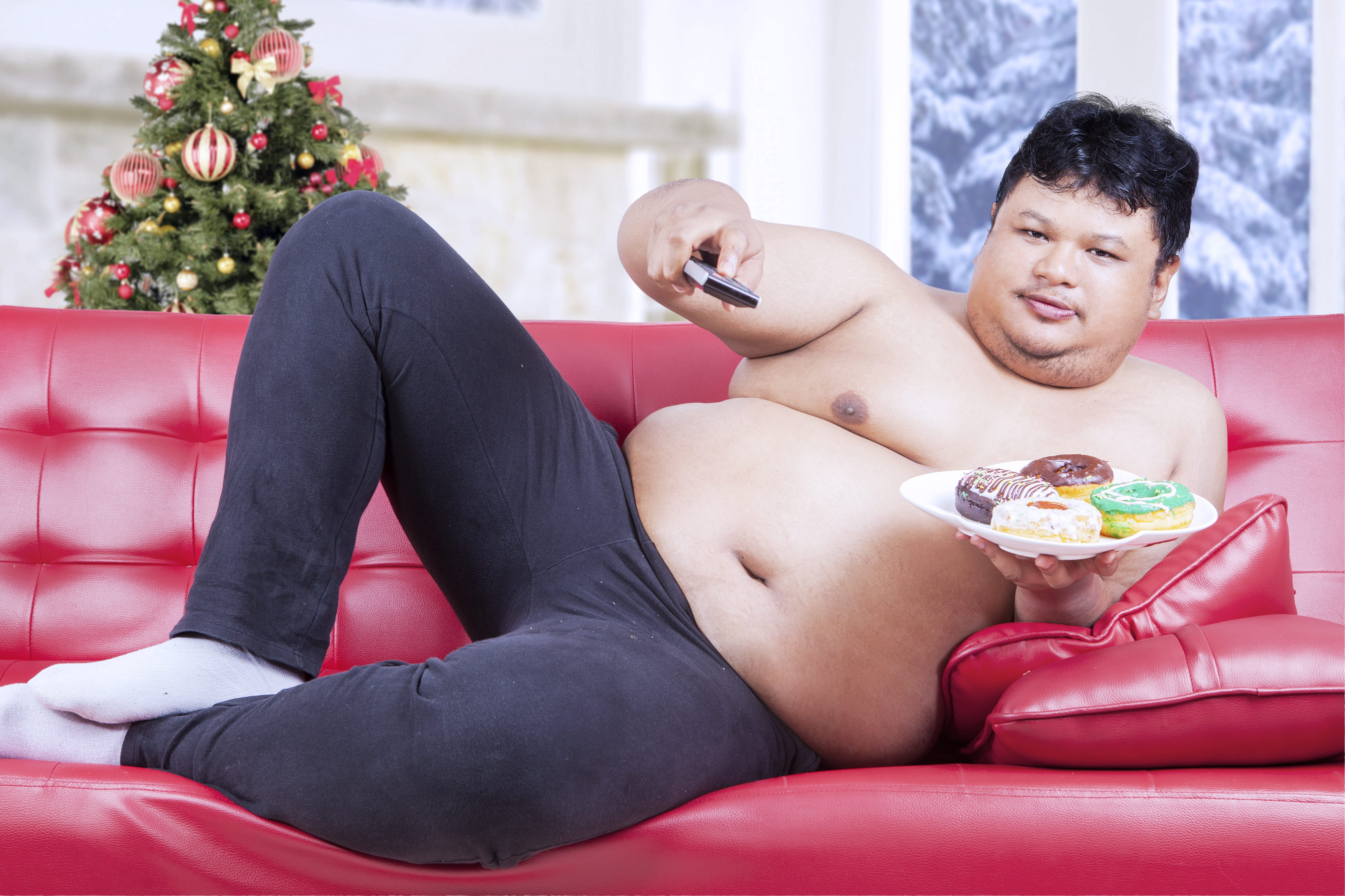 Толстяк лежит на диване