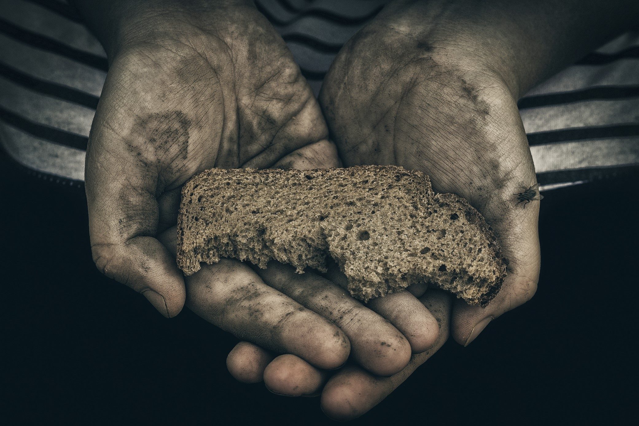 Голодный 20. Нищий с куском хлеба. Бедный ребенок с куском хлеба. Хлеб для бедных. Хлеб в руках бедняка.