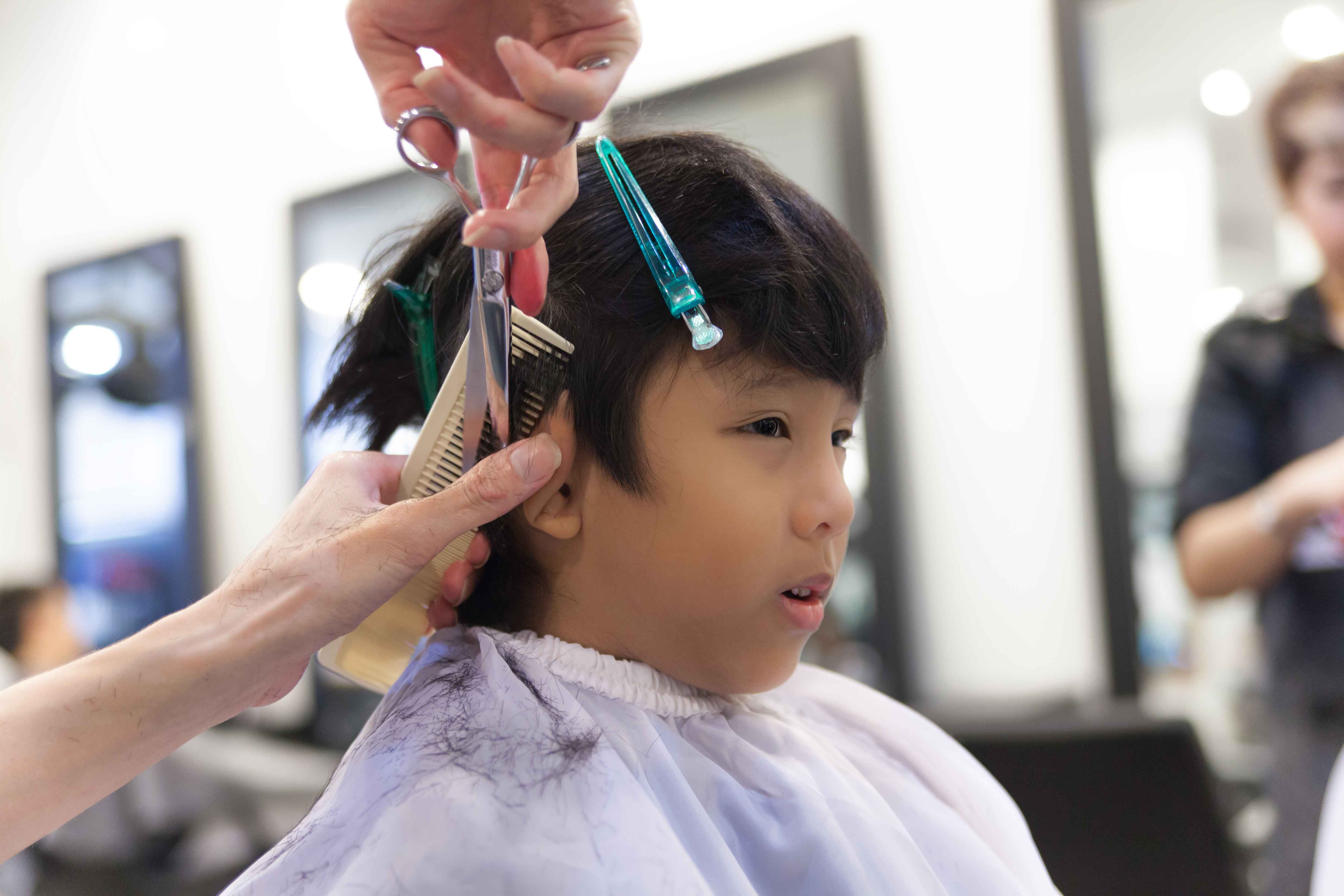 床屋で散髪される少年