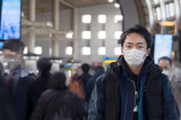 外でマスクをする男性