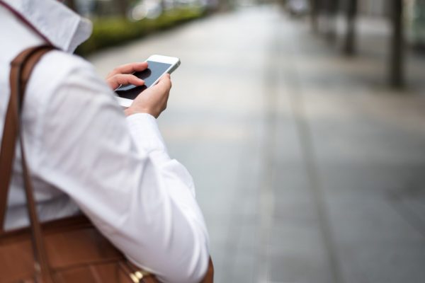 スマホで調べ物をする女性