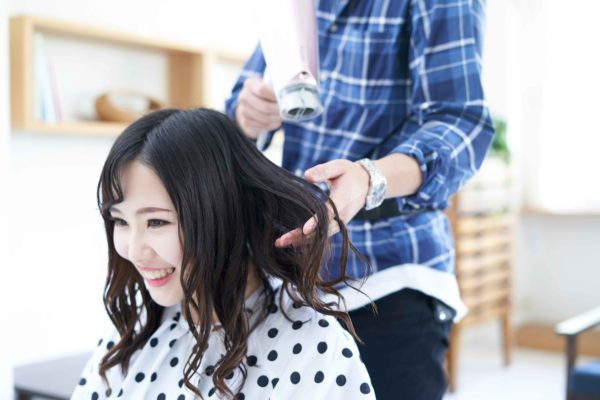 美容院で髪を切る女性