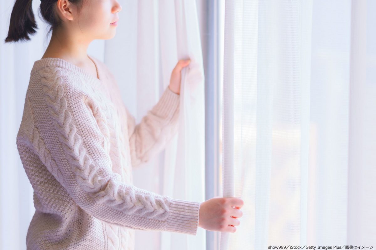 窓の外を眺める女性