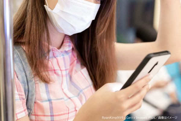 電車でスマホを見る女性