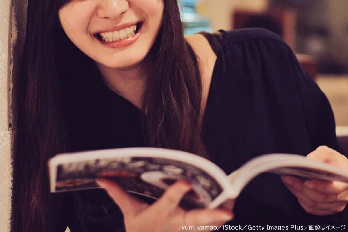 雑誌を読みながら笑う女性