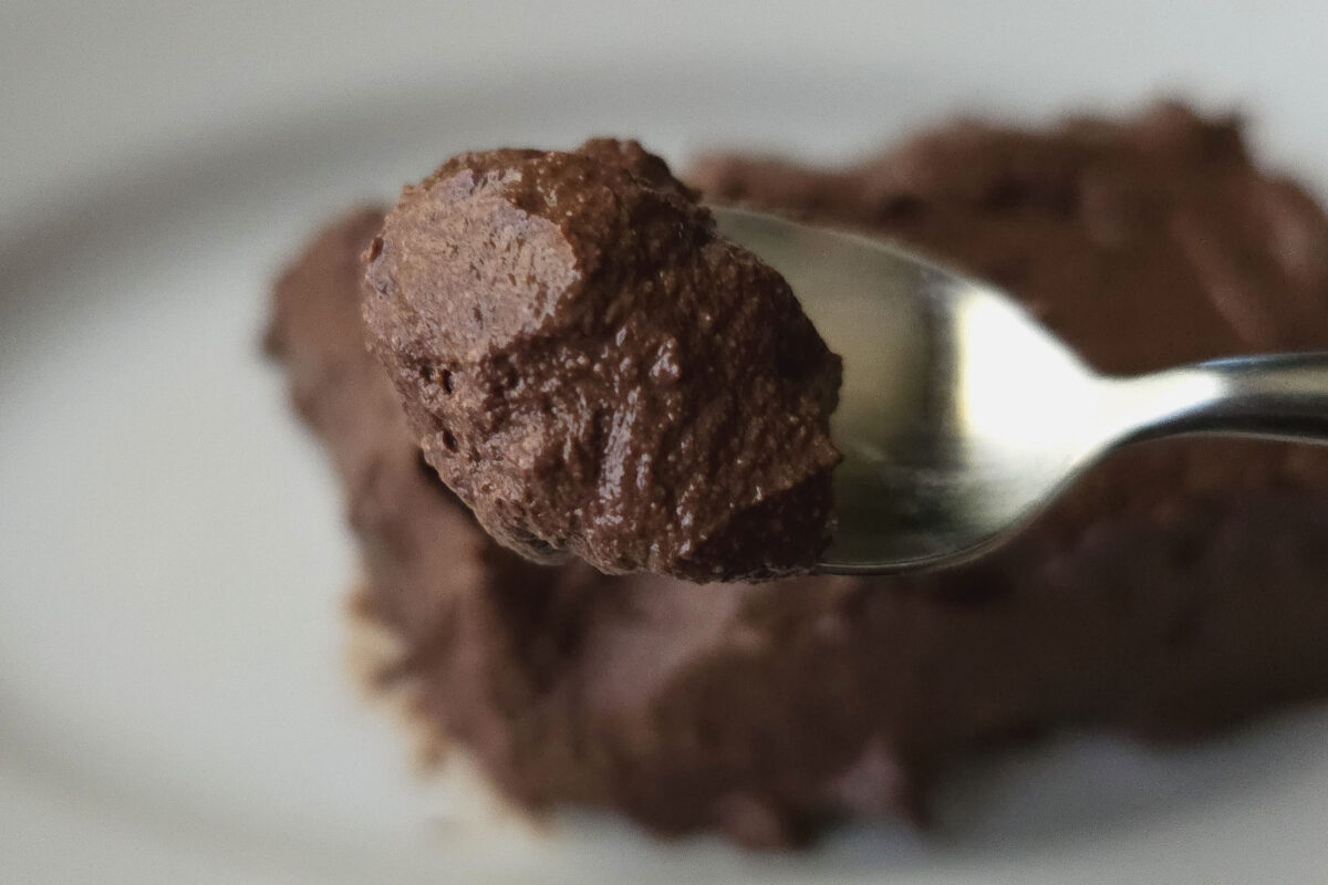 濃厚なチョコレートスイーツを食べたいけれど、カロリーが気になる。そして、お菓子作りは何となくハードルが高い。なんとか手軽にヘルシーに楽しむ方法はないものだろうか。 そこで、独学で考えたカフェスイーツをSNSで紹介しているsyun cookingの「パックそのまま生チョコケーキ」を実際に作って試してみた。 ■材料はたった3つ 今回のレシピで使う材料はこちら。 ・絹ごし豆腐...150g ・砂糖...約30g ・ココアパウダー...約40g 材料はたったこれだけしか使わない。砂糖の量は、お好みに合わせて調節しよう。 ■混ぜて冷やすだけであっという間に完成 絹ごし豆腐をボウルに入れる。水分が入ると固まりにくくなるので、しっかり水気を切ることがポイントだ。この後、なめらかになるまでしっかり混ぜていこう。 このくらいになればOK。砂糖を加えて、ジャリジャリ感がなくなるまで、なじませるイメージで混ぜる。 ココアパウダーを入れたら、ダマや粉っぽさがなくなるまでさらに混ぜよう。 豆腐のパックに生地を流し入れ、表面を整える。 冷蔵庫で3時間以上、しっかり固まるまで冷やす。 パックから出したらでき上がり。パックそのままを使うので、あまり凹凸のないパックに入った豆腐を選んだ方が、扱いやすいかもしれない。 ■ココアパウダーとは思えない濃厚さ とろっとなめらかな食感で、想像以上の濃厚さ。ココアパウダーでなはく、チョコレートを使ったかのような味わいだ。 食べ応えがあって満足度が高いのに、豆腐でできているという安心感もうれしい。甘さも控えめなので、ダイエット中のおやつにもよさそうだ。 コメント欄でも、「思ってた以上に濃厚で、豆腐だとは思いませんでした。また作ります！」「簡単すぎる！って早速作ったらめちゃくちゃ美味しくて笑ってしまった。あまりがちなココアパウダーを消費できるのもありがたい。こんなに簡単でこんなに美味しいの神すぎる。」「豆腐のパックそのまま使うのかしこい」などの声が見られている。バターも小麦粉も使わないお手軽スイーツレシピ、気になった人はぜひ作ってみてほしい。 ■パックそのまま生チョコケーキ・実食