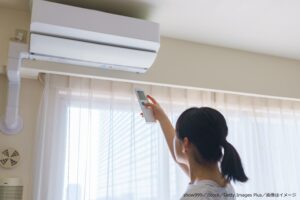 エアコンをつける女性