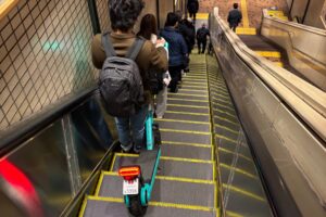 LUUPとエスカレーターに乗る男性