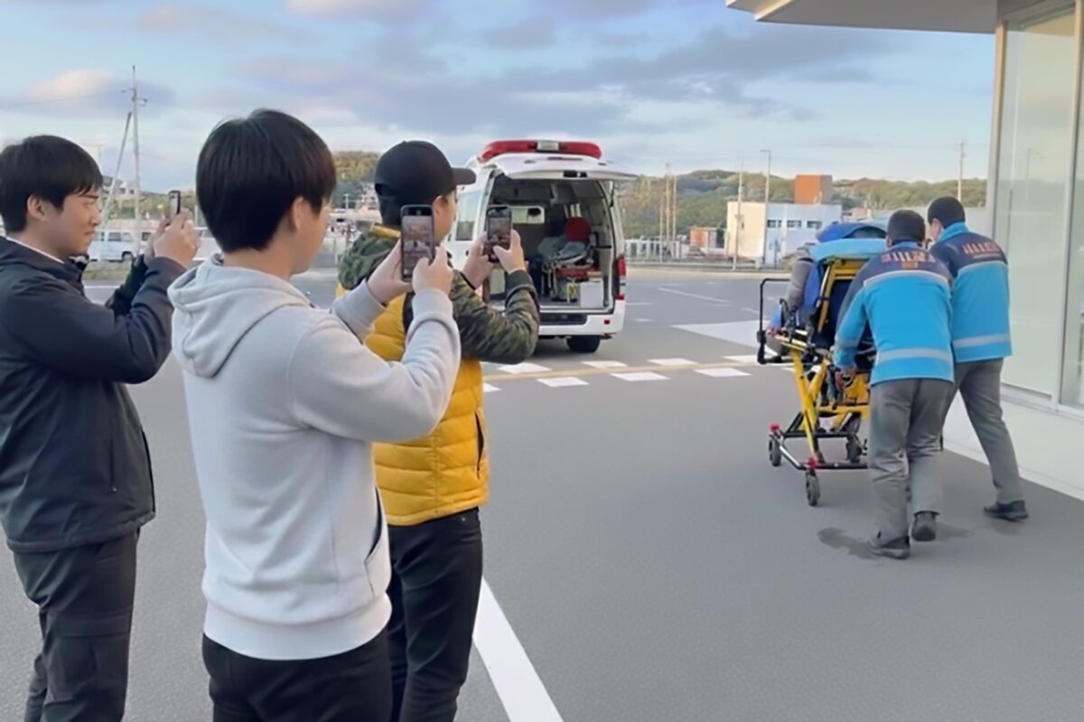 救急現場でケガ人を撮影するモラルのない人たちのイメージ