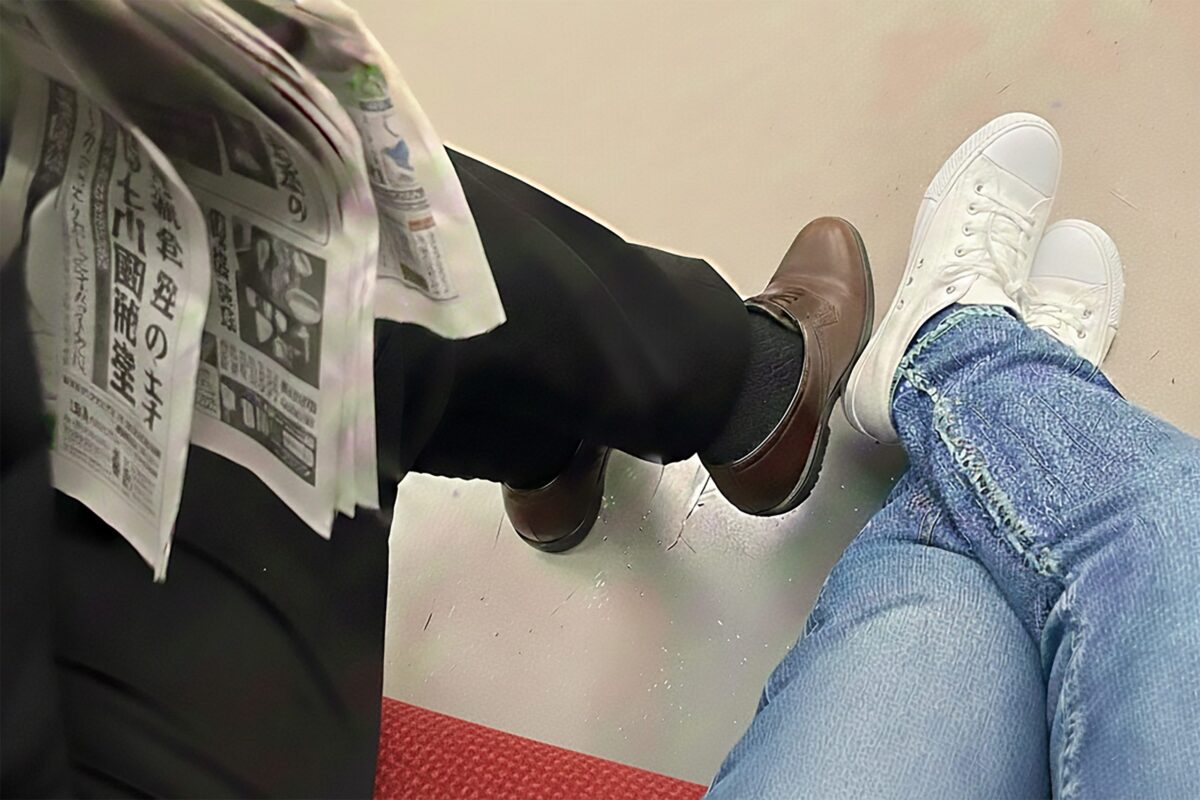 電車で脚組む人のイメージ