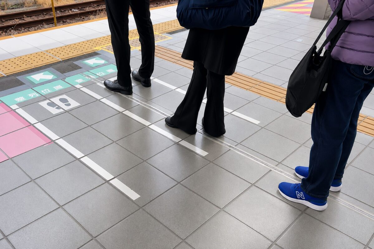 駅ホームで1列に並ぶ人々